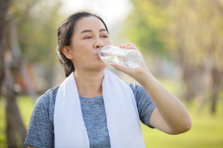 Woman drinking water after exercising while on dialysis