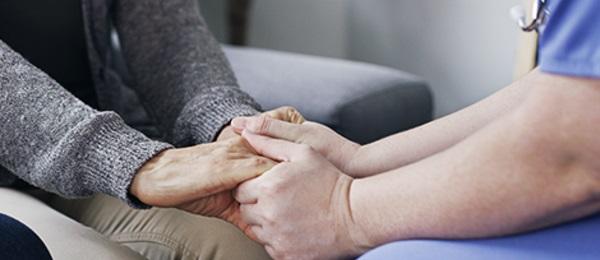 patient undergoing dialysis holds hcp's hands for comfort